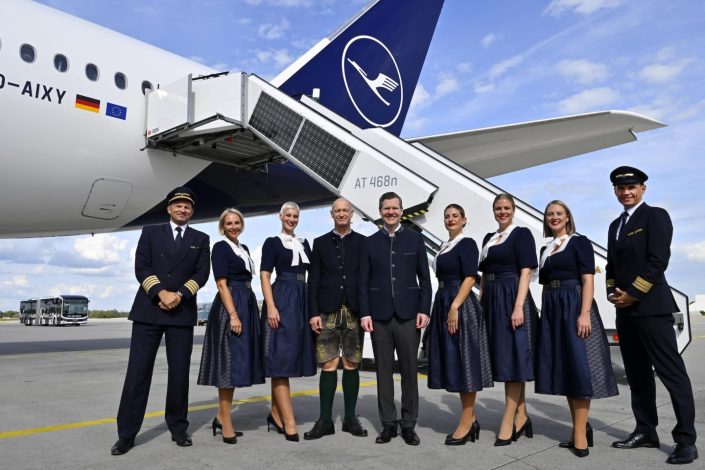 Flughafen München Oktoberfest mit Lufthansa Trachtencrew vor einem Flugzeug auf dem Vorfeld des Airports