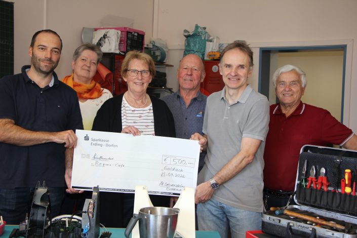 Spendenübergabe an das Repair-Café Hallbergmoos: Vertreter des AK Ortsverschönerung überreichen einen Scheck über 500 Euro an das Repair-Team.